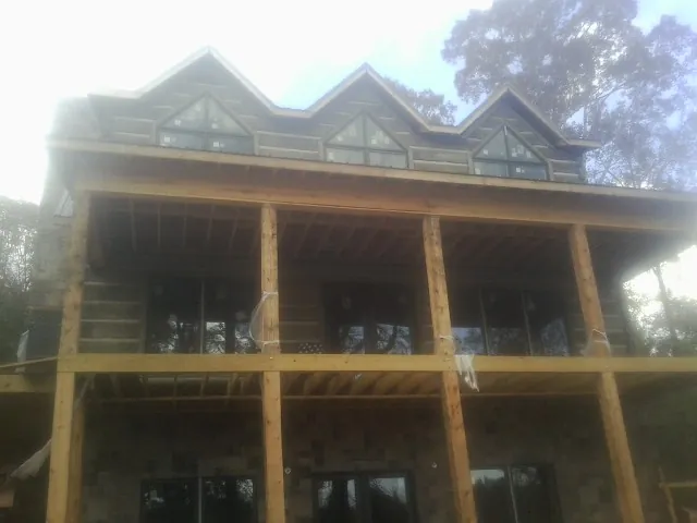 Dormers and porch framing on a large log home under construction — Roof Coating work by our crew in Pomeroy